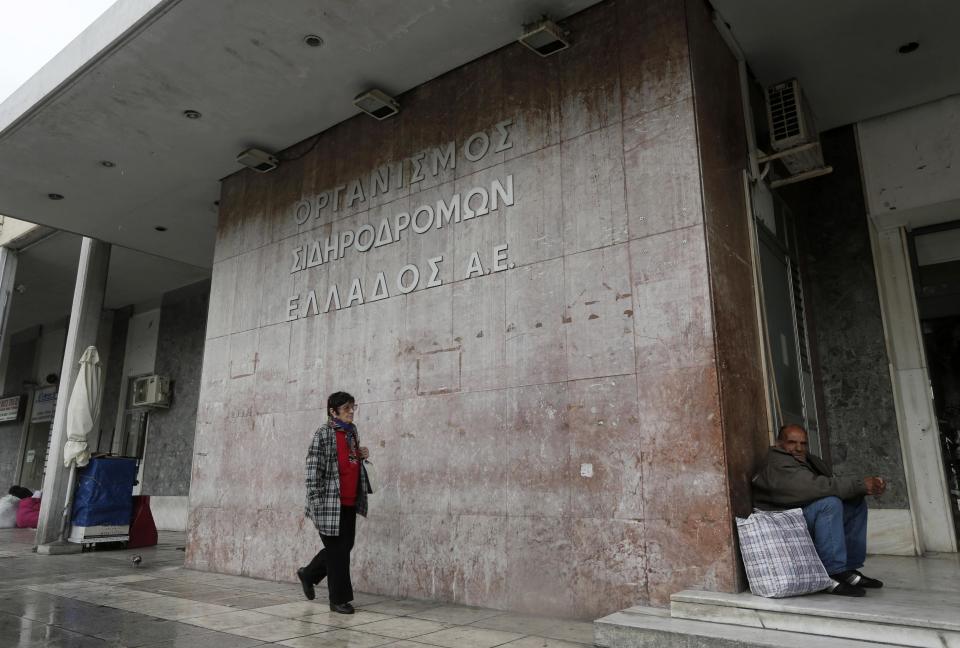 A man waits in front of a closed main railway station during a general 24 hour labour strike in Athens