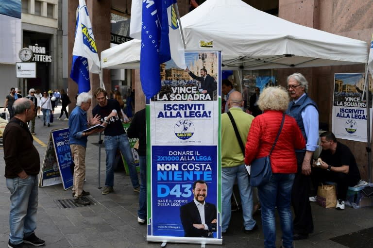 People gather at the stand of the far-right League to approve a programme which turns its back on austerity measures