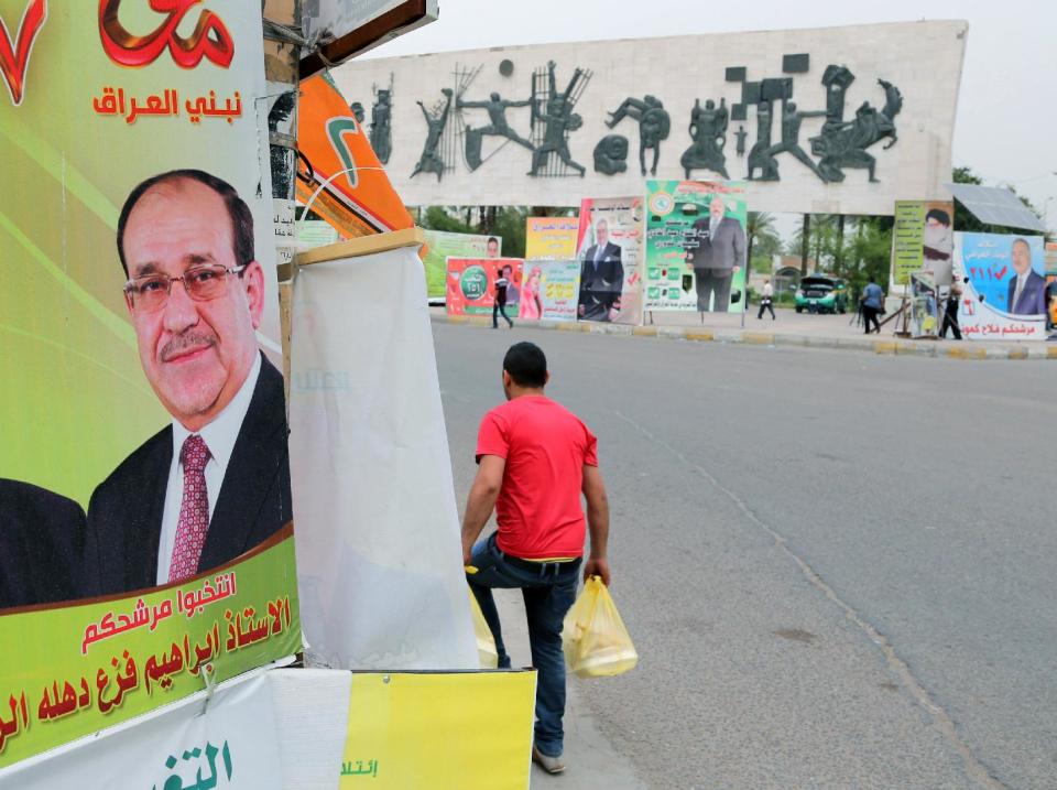 FILE - In this file photo taken on April 27, 2014 a man passes by a campaign poster of Iraqi Prime Minister Nouri al-Maliki in Baghdad, Iraq. If Iraqi Prime Minister Nouri al-Maliki wins a third four-year term in parliamentary elections Wednesday, he is likely to rely on a narrow sectarian Shiite base, only fueling divisions as Iraq slides deeper into bloody Shiite-Sunni hatreds. (AP Photo/Karim Kadim, File)