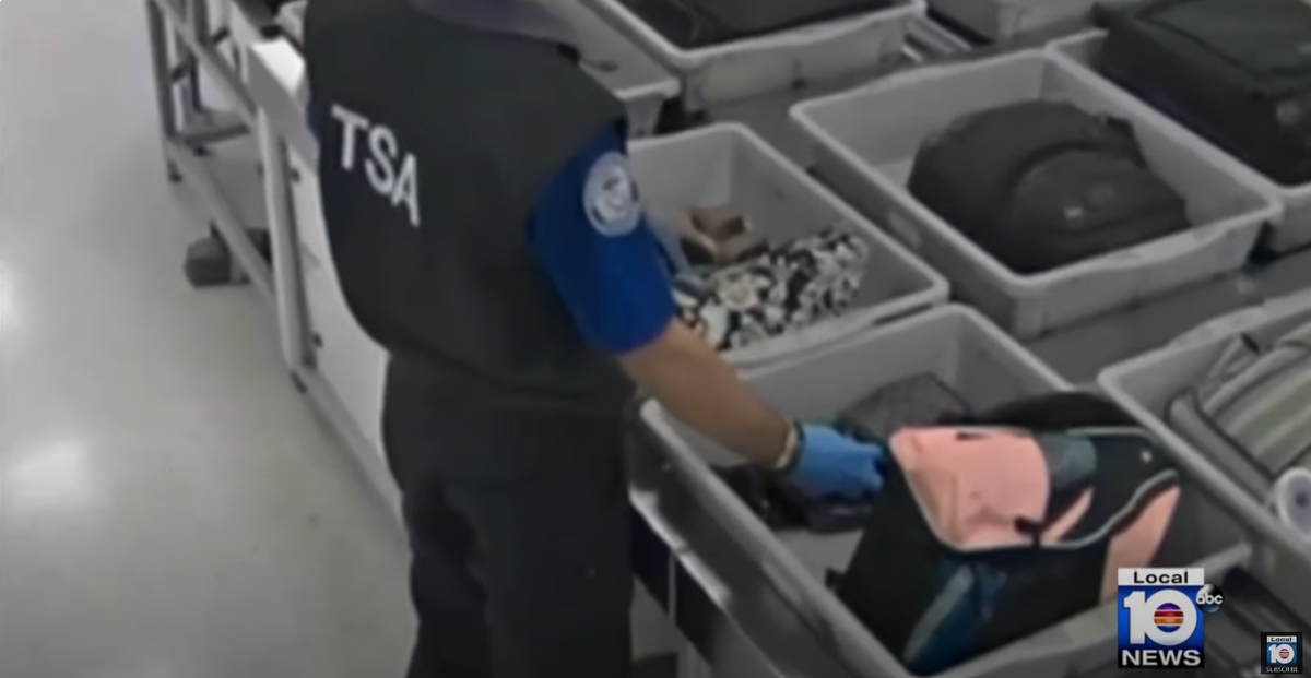 One TSA agent was caught slipping a wallet out a passenger’s bag (WPLG/YouTube)