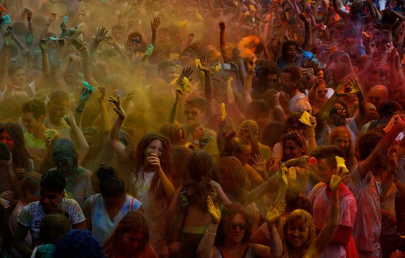 Participants throw special powders in the air during the Gay Pride parade at Moll de la Fusta in Barcelona