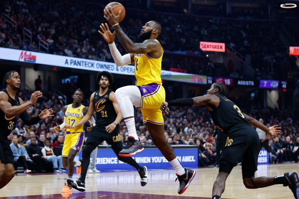 Los Angeles Lakers forward LeBron James (6) shoots between Cleveland Cavaliers guard Caris LeVert (3) and center Jarrett Allen (31) during the first half of an NBA basketball game Tuesday, Dec. 6, 2022, in Cleveland. (AP Photo/Ron Schwane)