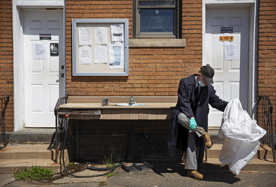 Rabbi Shmuel Plafker removes his protective suit after conducting seven burials Monday, April 6, 2020, as the chaplain for the Hebrew Free Burial Association at their cemetery in the Staten Island borough of New York. "It's ironic," said Plafker as he reflects after burying another potential coronavirus victim. "Spring is here. Everything is in bloom and people are dying." (AP Photo/David Goldman)