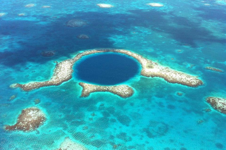 The Great Blue Hole off the coast of Belize is seen from a helicopter on a lovely spring day.