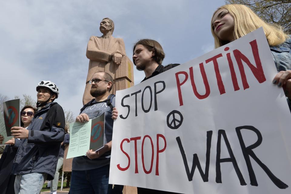 Demonstrators hold an anti-war poster during an anti-war and anti-Putin (Russian President Vladimir Putin) rally in Gorky Park in Bishkek, Kyrgyzstan, Saturday, March 26, 2022. (AP Photo/Vladimir Voronin)