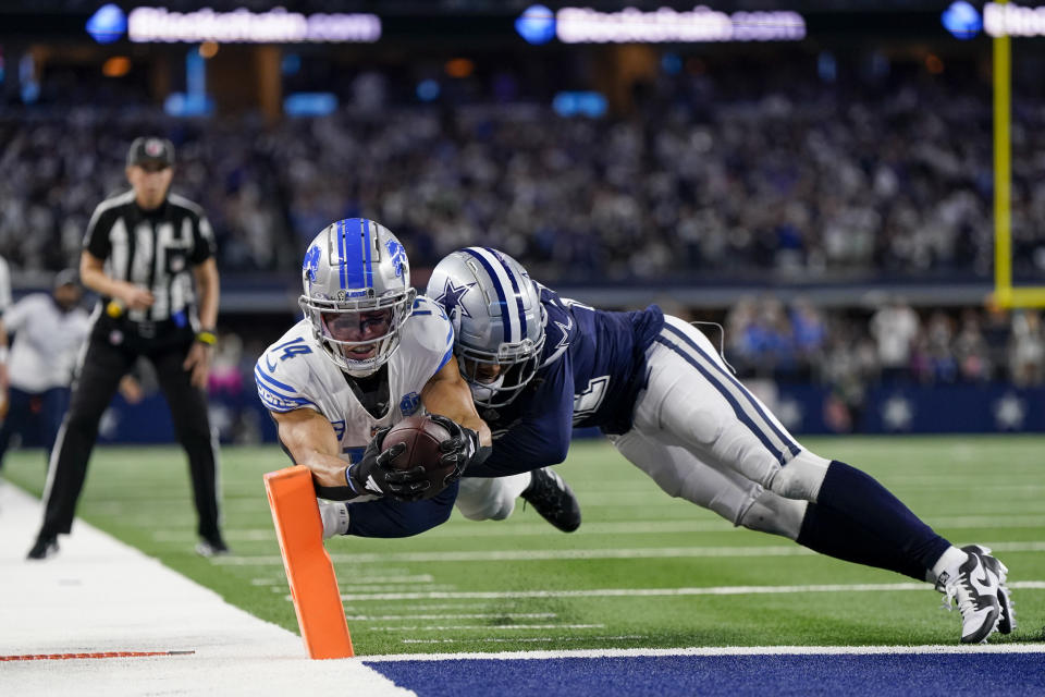 Detroit Lions wide receiver Amon-Ra St. Brown (14) scores a touchdown as Dallas Cowboys cornerback Stephon Gilmore (21) tries to stop him during the second half of an NFL football game, Saturday, Dec. 30, 2023, in Arlington, Texas. The Cowboys won 20-19. (AP Photo/Sam Hodde)