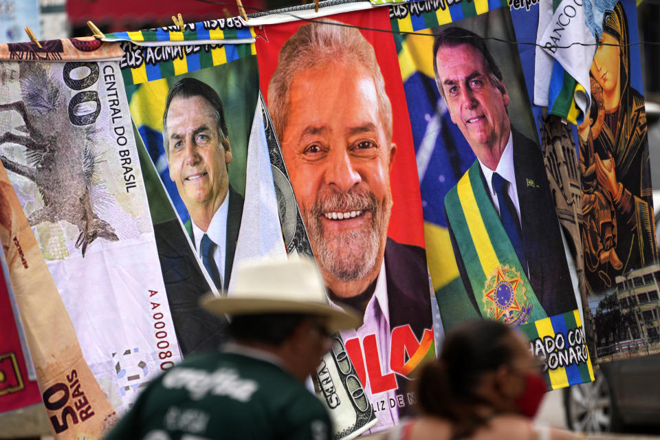 FILE - Towels with images of Brazilian presidential candidates, President Jair Bolsonaro and former President Luiz Inacio Lula da Silva, are for sale by a street vendor, hanging from a makeshift clothesline in Brasilia, Brazil, Thursday, Sept. 22, 2022. Despite the smoke clogging the air of entire Amazon cities, state elections have largely ignored environmental issues. (AP Photo/Eraldo Peres, File)