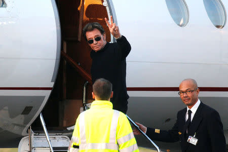 FILE PHOTO: French singer Johnny Hallyday waves to photographers as he boards a plane to leave Le Bourget Airport near Paris December 18, 2011. REUTERS/Benoit Tessier/File Photo