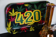 A 420 plate is displayed behind a glass bong on the shelves at Cloud 9 Cannabis, Saturday, April 13, 2024, in Arlington, Wash. The shop is one of the first dispensaries to open under the Washington Liquor and Cannabis Board's social equity program, established in efforts to remedy some of the disproportionate effects marijuana prohibition had on communities of color. (AP Photo/Lindsey Wasson)