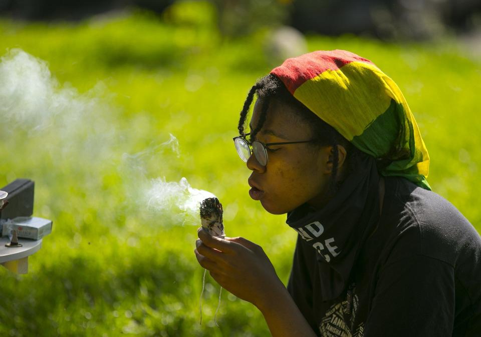 Evette Clayton, 19, burns sage during the "Light and Love BBQ" Juneteenth celebration at Goodale Park in 2020.