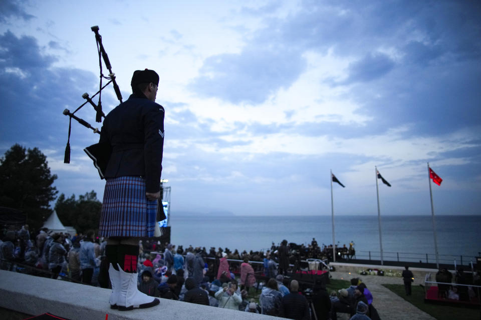 An Australian soldier stands after playing his pipe as people attend the Dawn Service ceremony at the Anzac Cove beach, the site of the April 25, 1915, World War I landing of the ANZACs (Australian and New Zealand Army Corps) on the Gallipoli peninsula, Turkey, early Tuesday, April 25, 2023. During the 108th Anniversary of Anzac Day, travelers from Australia and New Zealand joined Turkish and other nations' dignitaries at the former World War I battlefields for a dawn service Tuesday to remember troops that fought during the Gallipoli campaign between British-led forces against the Ottoman Empire army. (AP Photo/Emrah Gurel)
