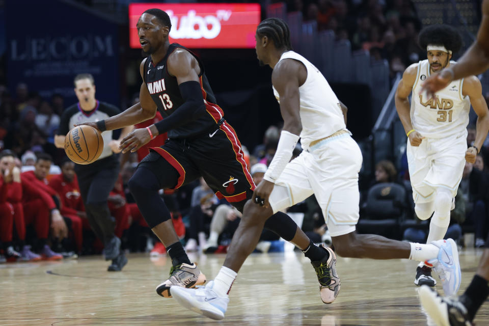 Miami Heat center Bam Adebayo (13) drives against Cleveland Cavaliers guard Caris LeVert during the second half of an NBA basketball game, Tuesday, Jan. 31, 2023, in Cleveland. (AP Photo/Ron Schwane)