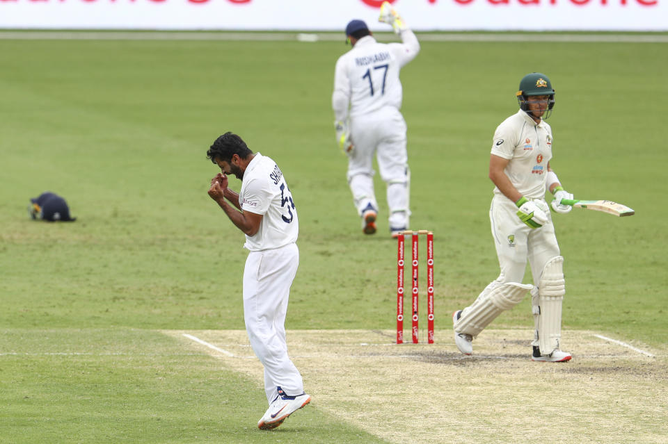 India's Shardul Thakur, left, celebrates the dismissal of Australia's Tim Paine, right, during play on day four of the fourth cricket test between India and Australia at the Gabba, Brisbane, Australia, Monday, Jan. 18, 2021. (AP Photo/Tertius Pickard)