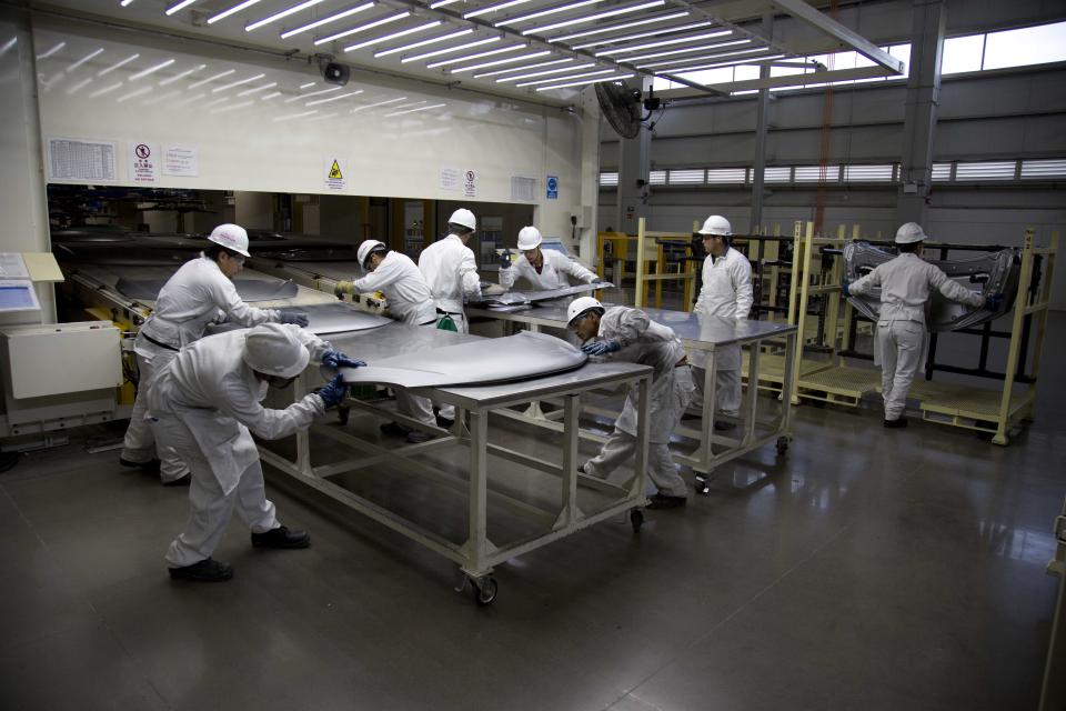 Employees at work in the new multibillion-dollar Honda car plant in Celaya, in the central Mexican state of Guanajuato, Friday, Feb. 21, 2014. Mexico is on track to overtake Japan and Canada and become the United States' No. 1 source of imported cars by the end of next year, part of a national manufacturing boom that has turned the auto industry into a bigger source of dollars than money sent home by migrants. (AP Photo/Eduardo Verdugo)