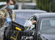 FILE - In this file photo dated Tuesday June 30, 2020, a coronavirus test sample is collected at a coronavirus testing station in Leicester, England. The British government insists that science is guiding its decisions as the country navigates its way through the coronavirus pandemic. But a self-appointed group of independent experts led by a former government chief adviser says it sees little evidence-based about Britain’s response. Unlike other countries, the scientific opposition to Britain’s approach is remarkably organized. The independent group sits almost in parallel to the government’s own scientists, assesses the same outbreak indicators and has put out detailed reports on issues such contact tracing, reopening schools and pubs, and relaxing social distancing. (AP Photo/Rui Vieira, File)