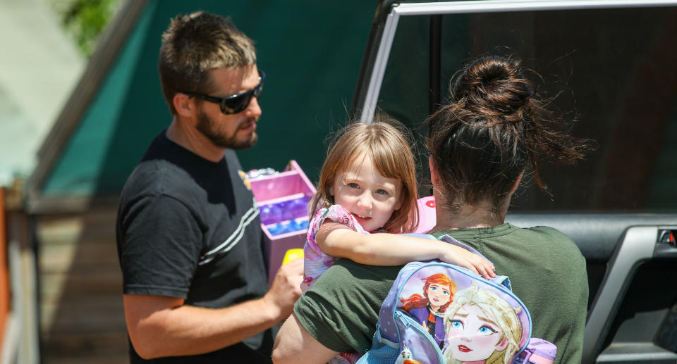 Cleo Smith is carried inside a friend's house by her mother on Thursday.