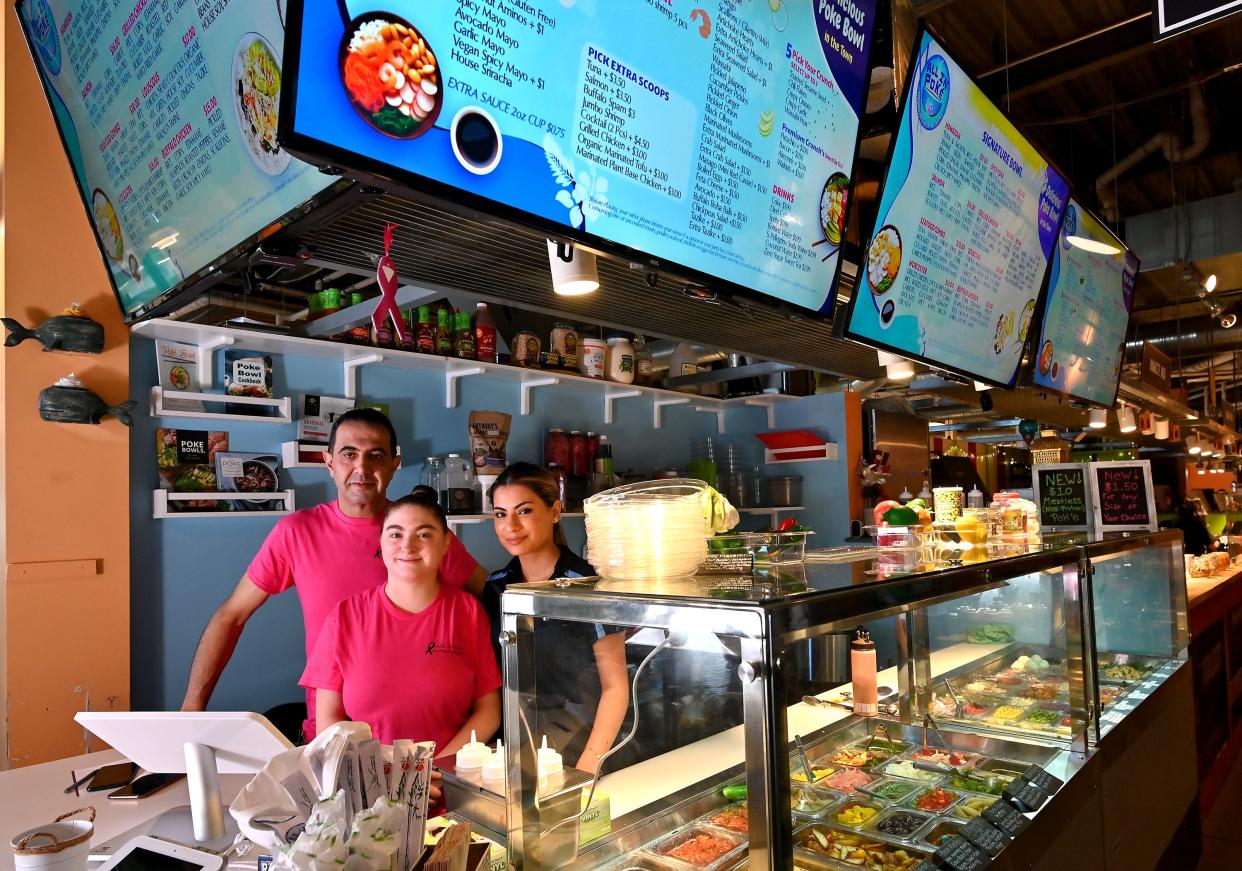 All In Poke at the Worcester Public Market owners Eli Aswad and Liri McDaniel with employee Zuzan Abdo, right.