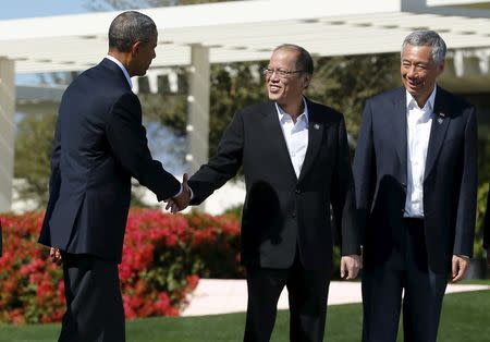 U.S. President Barack Obama (L) shake hands with Philippine President Benigno Aquino as Singapore Prime Minister Lee Hsien Loong looks on as the leaders from the 10-nation Association of Southeast Asian Nations (ASEAN) summit finish taking a family photo in Rancho Mirage, California, February 16, 2016. REUTERS/Mike Blake