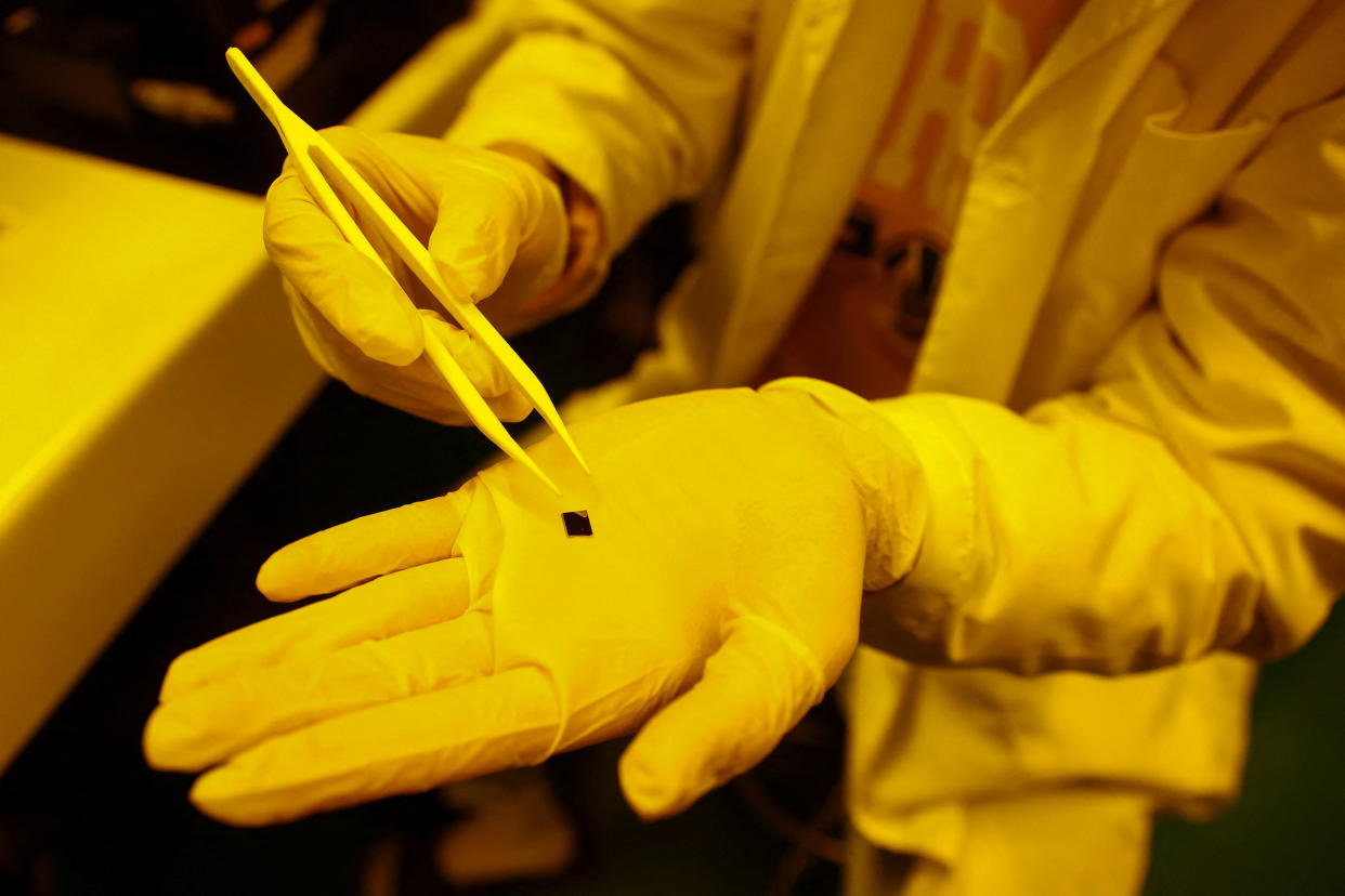 A student shows a chip that he tests inside a yellow room lab in Tainan, Taiwan, February 23, 2022. Picture taken February 23, 2022. REUTERS/Ann Wang