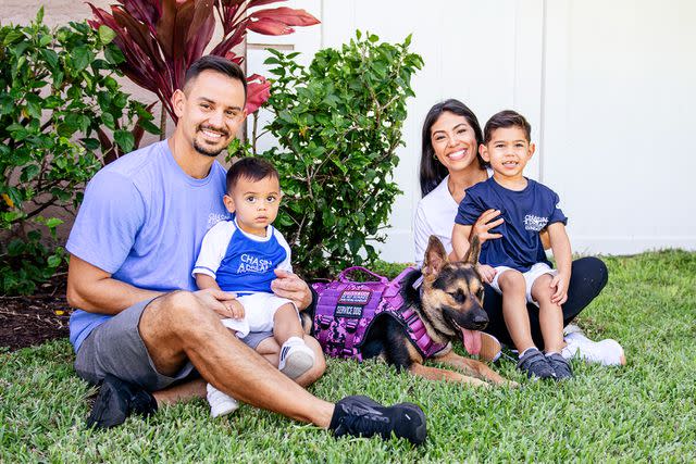 <p>Lori Griffith/Chasin A Dream Photography</p> Four-year-old Giovanni Bajer (right) and his family sitting outside with their rescue dog Gracie, who is training to be Giovanni's seizure alert dog