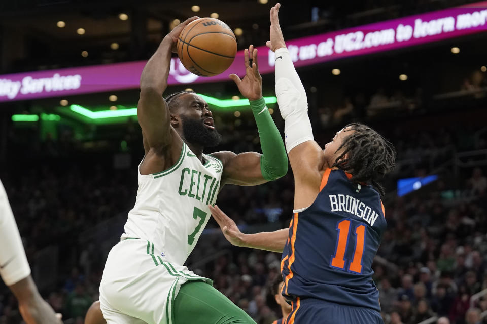 Boston Celtics guard Jaylen Brown (7) drives toward the basket as New York Knicks guard Jalen Brunson (11) defends during the first half of an NBA basketball game Thursday, Jan. 26, 2023, in Boston. (AP Photo/Steven Senne)