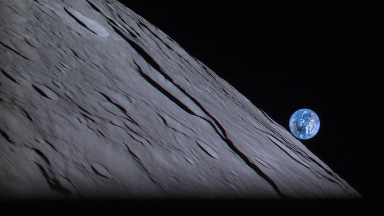  the earth rising above the moon during a solar eclipse on april 20. the shadow of the moon is visible on the earth's surface 