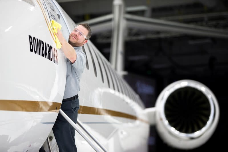 Bombardier employee polishes sign of Bombardier's Global 7500, the first business jet to have a queen-sized bed and hot shower, is shown during a media tour in Montreal