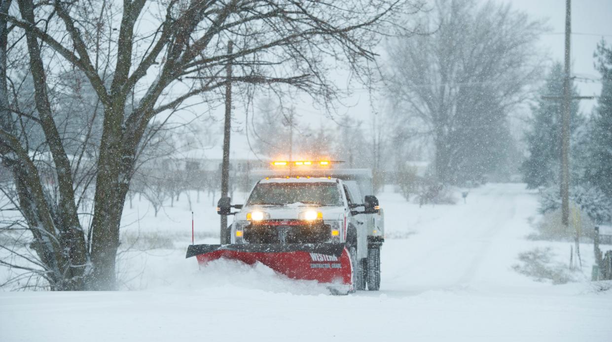 A county snowplow clears a rural road in Walla Walla, Wash., on Feb. 12, 2021.