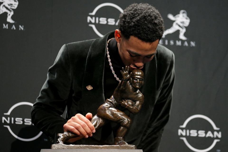 Bryce Young kisses the trophy.