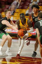 Minnesota guard Both Gach (11) works between the defense of North Dakota forward Brady Danielson (15) and guard Tyree Ihenacho (4) in the first half of an NCAA college basketball game Friday, Dec. 4, 2020, in Minneapolis. (AP Photo/Bruce Kluckhohn)