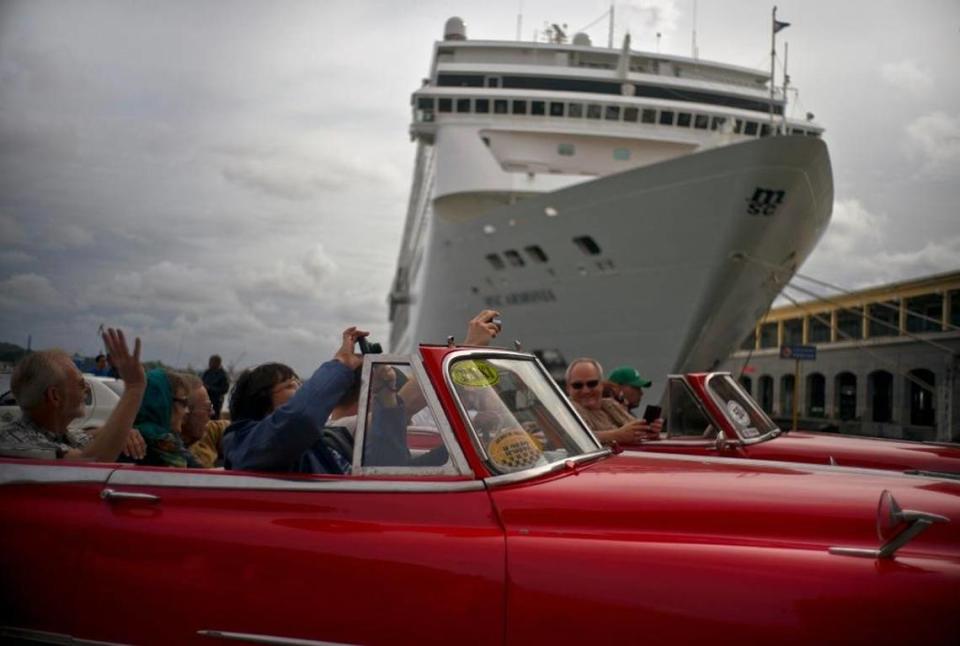 Tourists in Cuba in January 2018 tour Havana in private American classic cars, as they drive in front of a cruise ship. 