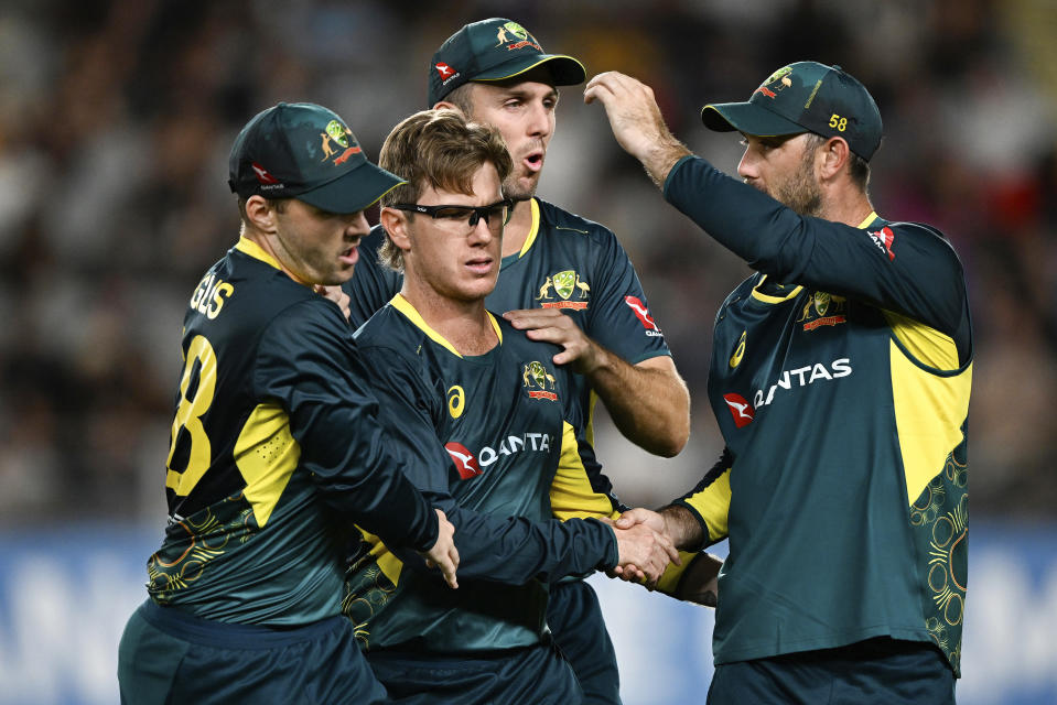 Australian bowler Adam Zampa is congratulated by teammates after taking the wicket of New Zealand's Glenn Phillips during the T20 cricket international between Australia and New Zealand at Eden Park in Auckland, New Zealand, Friday, Feb. 23, 2024. (Andrew Cornaga/Photosport via AP)