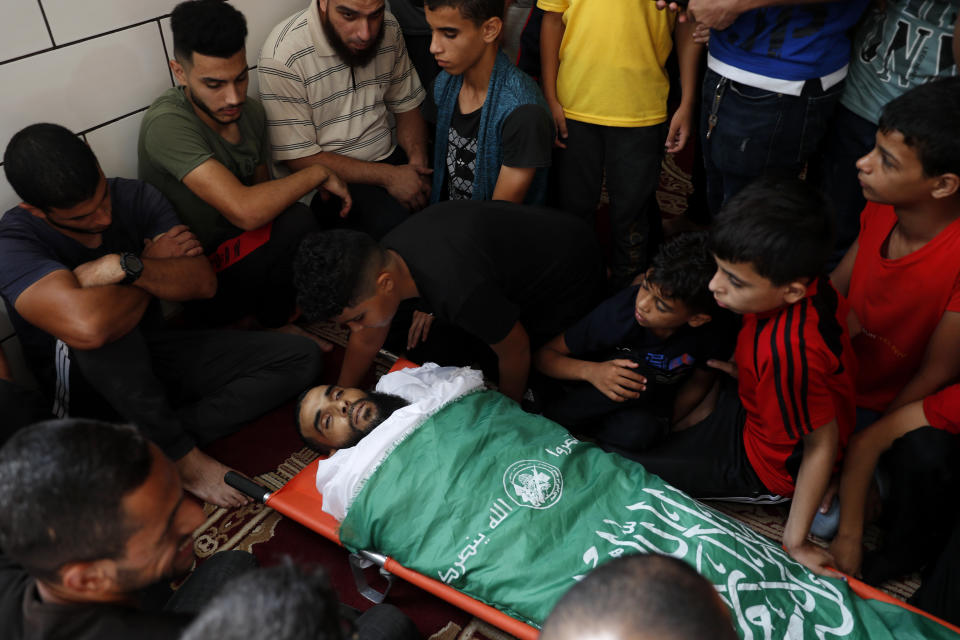 Relatives and mourners gather around the body of Mohammed Abu Ammar at the main mosque during his funeral in Bureij refugee camp, central Gaza Strip, Thursday, Sept. 30, 2021. Israeli troops shot and killed Abu Ammar, a 40-year-old Palestinian, on Thursday as he was setting bird traps in the Gaza Strip near the Israeli border, his family said. The military said it was investigating. (AP Photo/Adel Hana)