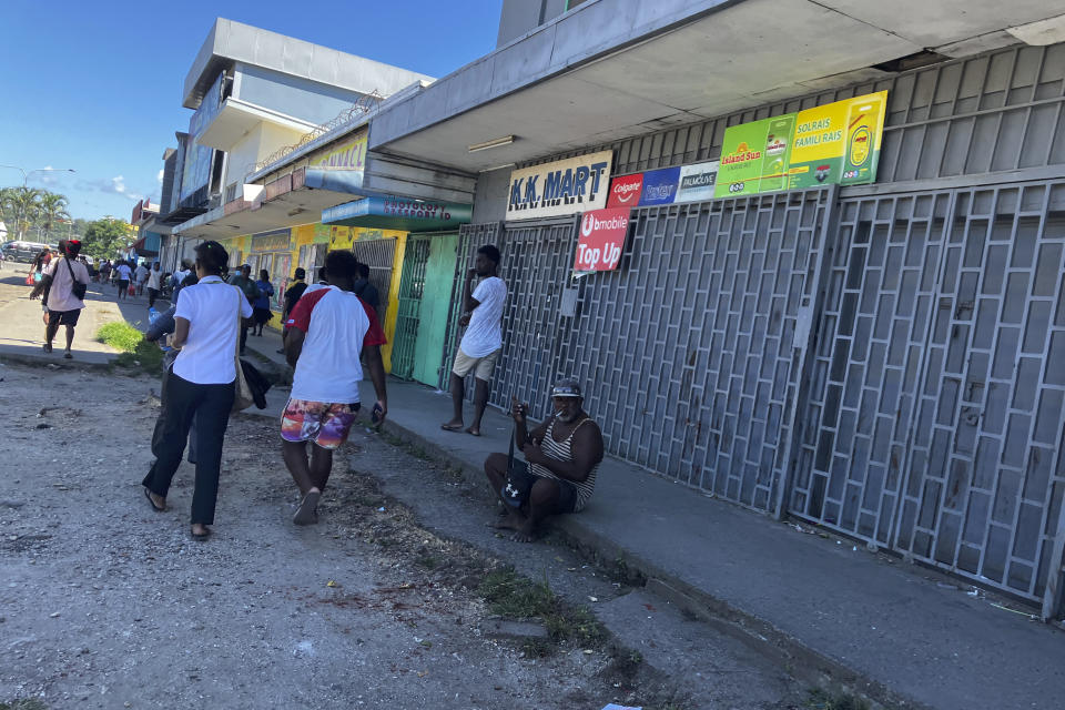 People gather outside shuttered stores in Honiara, Solomon Islands, following an earthquake, Tuesday, Nov. 22, 2022. A powerful earthquake jolted the Solomon Islands Tuesday afternoon, overturning tables and sending people racing for higher ground. (AP Photo/Charley Piringi)