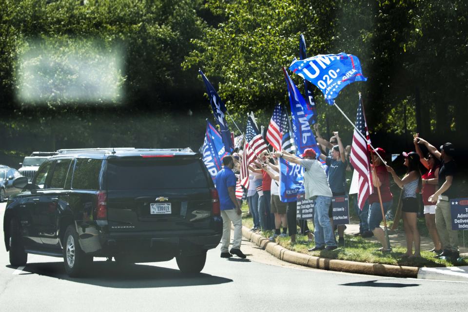 Supporters of President Donald Trump and protesters hold banners and wave as the motorcade of President Trump leaves the Trump National Golf Club in Sterling, Va., Sunday, Aug. 30, 2020. (AP Photo/Manuel Balce Ceneta)