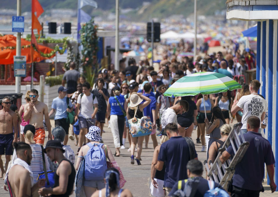 People walk along the promenade near the beach in Bournemouth. Britons are set to melt on the hottest UK day on record as temperatures are predicted to hit 40C. Picture date: Tuesday July 19, 2022.