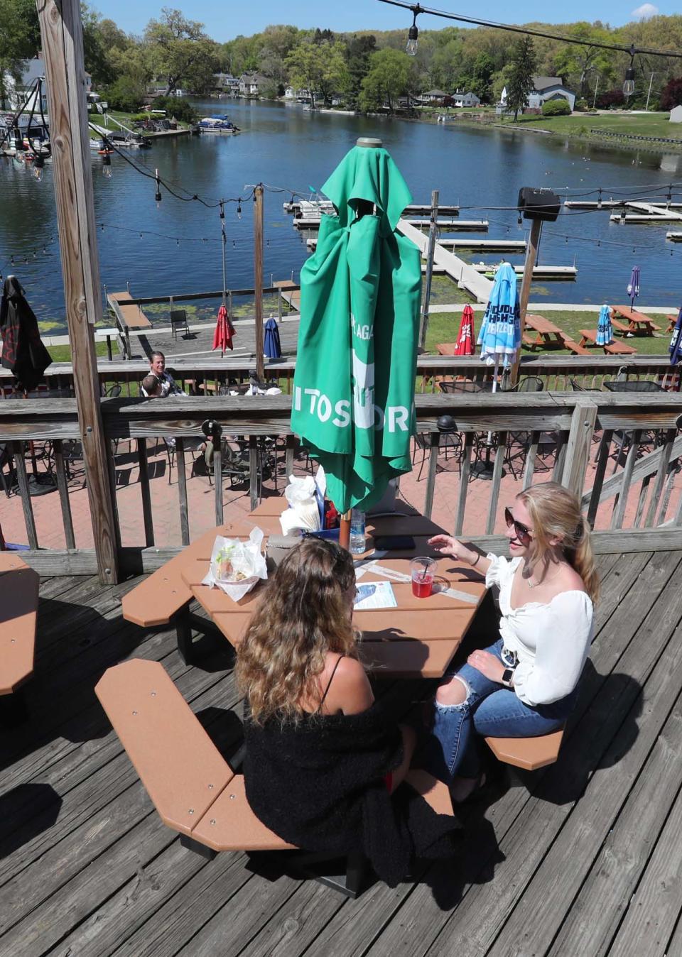 Savannah Dean, left, and Hannah Carter, both of Green, enjoy the sunshine outside last year at the Upper Deck overlooking the water.