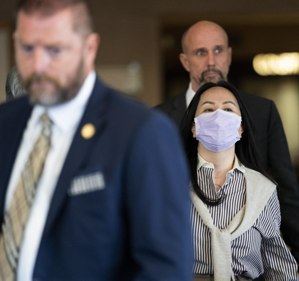 Meng Wanzhou is surrounded by security as she leaves B.C. Supreme Court in Vancouver, British Columbia, Monday, Sept. 28, 2020. The senior executive for Chinese communications giant Huawei Technologies was in court arguing that her extradition to the U.S. should be halted because her rights have been violated. (Jonathan Hayward/The Canadian Press via AP)