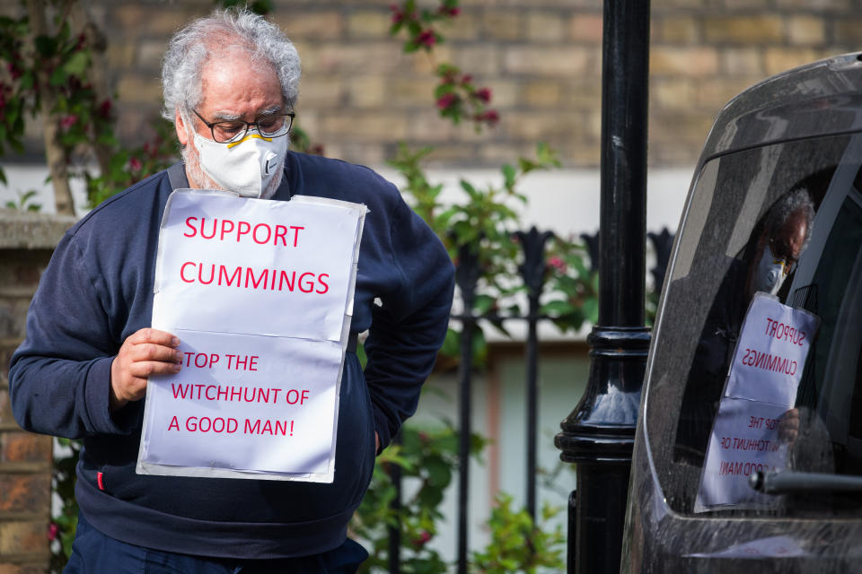 LONDON, ENGLAND - MAY 27: A supporter of the Chief Advisor to Prime Minister Boris Johnson, Dominic Cummings, waits for him to leave his home on May 27, 2020 in London, England. On March 31st 2020, Downing Street confirmed to journalists that Dominic Cummings, senior advisor to British Prime Minister Boris Johnson, was self-isolating with COVID-19 symptoms at his home in North London. Durham police have confirmed that he was actually hundreds of miles away at his parent's house in the city, having travelled with his wife and young son. (Photo by Leon Neal/Getty Images,)