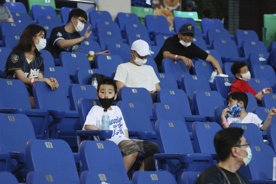 FILE - In this May 8, 2020, file photo, fans sit in the stands for a baseball game at Xinzhuang Baseball Stadium in New Taipei City, Taiwan. The Taiwan baseball league is continuing as a trailblazer for sports resuming after the lockdown in the coronavirus pandemic. An easing of restrictions by the government on Sunday, June 7, 2020 allows more fans at the ballparks and allows them to sit closer together while they’re supporting their teams in the Taiwan-based CPBL. Fans are only required to wear face masks when they're not in their seats and ball parks are allowed to be up to 50% capacity. (AP Photo/Chiang Ying-ying, File)