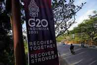 Motorists ride past a G20 banner in Nusa Dua, Bali, Indonesia, Thursday, July 7, 2022. Foreign ministers from the Group of 20 leading rich and developing nations are gathering in Indonesia's resort island of Bali for talks bound to be dominated by the conflict in Ukraine despite an agenda focused on global cooperation and food and energy security. (AP Photo/Dita Alangkara)