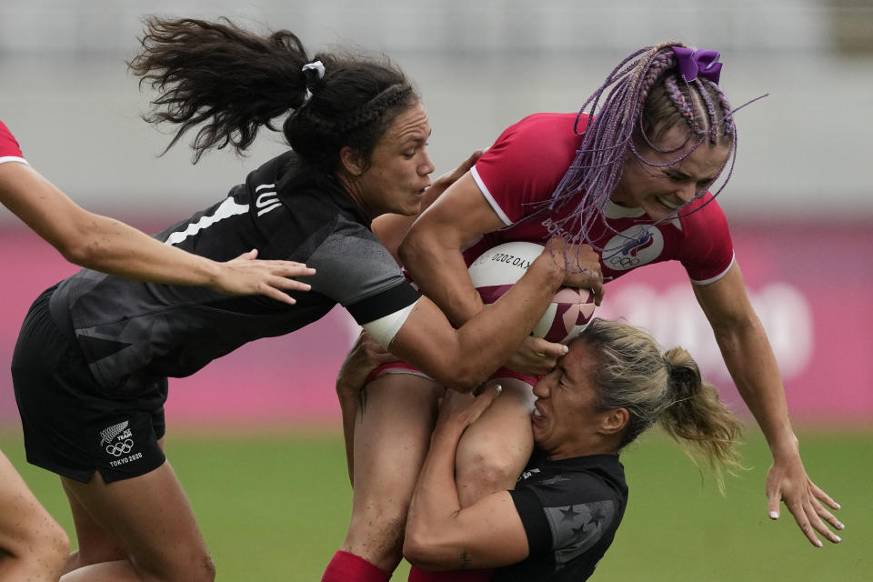 Russian Olympic Committee's Alena Tiron, right, is taken down by New Zealand's Sarah Hirini, bottom, and Ruby Tui, in their women's rugby sevens match at the 2020 Summer Olympics, Friday, July 30, 2021 in Tokyo, Japan. (AP Photo/Shuji Kajiyama)