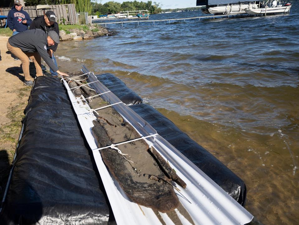 Ho-Chunk Nation President Marlon WhiteEagle (CQ)  touches a just recovered 3,000-year-old dugout canoe Thursday, September 22, 2022 from Lake Mendota in Madison, Wis. With WhiteEagle is  William Quackenbush, tribal historic preservation officer for the Ho-Chunk Nation. It is the second significant historic canoe discovery from the Wisconsin Historical Society’s maritime archeologist, Tamara Thomsen, who also discovered a 1,200-year-old dugout also found in the lake last year.