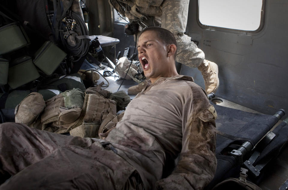 Lance Cpl. Blas Trevino of the 1st Battalion, 5th Marines, shouts out as he is rescued on a medevac helicopter from the U.S. Army's Task Force Lift "Dust Off", Charlie Company 1-214 Aviation Regiment after he got shot in the stomach outside Sangin, in the Helmand Province of southern Afghanistan on June 11, 2011. The Army's 'Dust Off' crew needed two attempts to get him out, as they were fired upon and took five rounds of bullets into the tail of their aircraft. (AP Photo/Anja Niedringhaus, File)