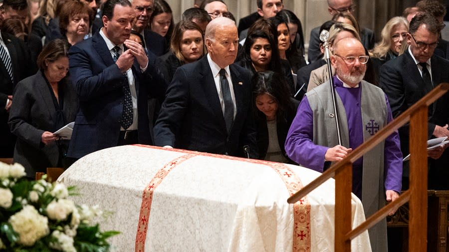 President Biden rests his hand on the casket of late Justice Sandra Day O'Connor during her funeral at the Washington National Cathedral