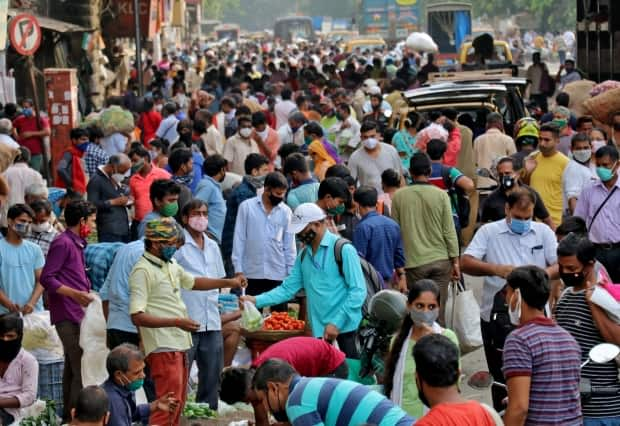 People shop at a crowded marketplace in Mumbai, India, on Wednesday while a new COVID-19 variant spreads like wildfire.