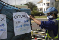 FILE - An airport worker handles the cargo of COVID-19 vaccines, donated through the U.N.-backed COVAX program, on arrival in Antananarivo, Madagascar, May 8, 2021. COVAX, created to share coronavirus vaccines fairly, already scaled back its pledge to the world's poor once. Now, to meet even that limited promise, it would have to deliver more than a million doses every hour until the end of the year. (AP Photo/Alexander Joe, File)