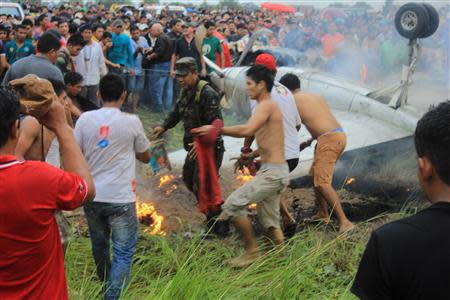 People gather around a Fairchild Swearingen Metroliner aircraft of Bolivian airliner AEROCON that crashed on its approach to the Riberalta airport in the Beni Province, November 3, 2013. Eight persons were killed and nine injured, according to local media report. REUTERS/ABI/Bolivian Presidency/Handout