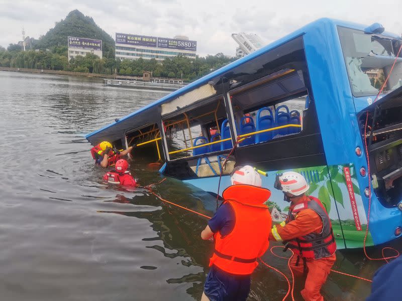 Rescue workers are seen at the site where a bus carrying students plunged into a reservoir, in Anshun