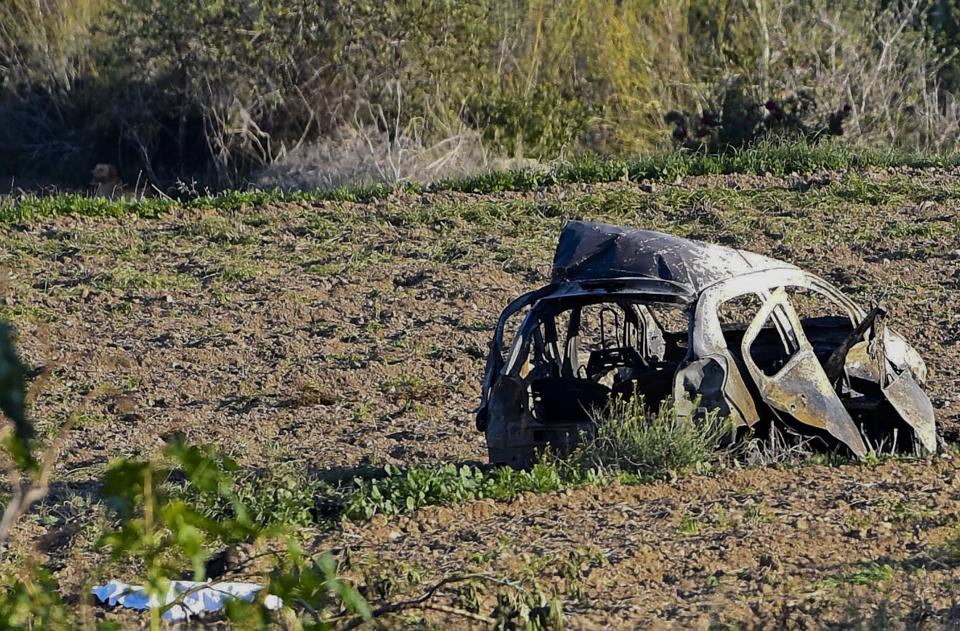 FILE - The wreckage of the car of investigative journalist Daphne Caruana Galizia lies next to a road in the town of Mosta, Malta, Monday, Oct. 16, 2017. The trial of two brothers charged in the car-bomb assassination of a Maltese journalist who investigated corruption in the tiny island nation began Friday, Oct. 14, 2022, nearly five years after the slaying that sent shockwaves across Europe. (AP Photo/Rene Rossignaud, File)